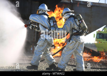 Le Cpl. Miguel Avalos et lance le Cpl. Brendan Bowles démontrer les techniques appropriées pour mettre un feu lors d'un événement de tir réel sur Marine Corps Air Station New River, N.C., janv. 19, 2017. Pendant la formation, les Marines gardez suffisamment de l'eau avec eux pour la formation et pour l'urgence. Avalos et Bowles sont rescuemen avec Marine Corps Air Station New River's Aircraft division incendie de secours. (U.S. Marine Corps photo par le Cpl. Melodie Snarr) Banque D'Images