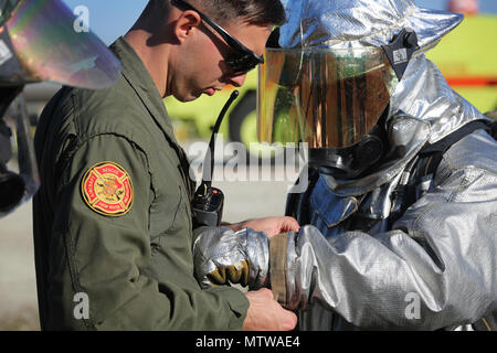 Le Sgt. Aaron Mack ajuste le Cpl. Miguel Avalos's gear lors d'un événement de tir réel sur Marine Corps Air Station New River, N.C., janv. 19, 2017. La formation et la tuyauterie de gaz propane utilisé pour simuler les incendies à l'intérieur et l'extérieur d'un aéronef. Mack est un assistant animateur de section avec Marine Corps Air Station New River's Aircraft division incendie de secours. Avalos est un rescueman avec Marine Corps Air Station New River's Aircraft division incendie de secours. (U.S. Marine Corps photo par le Cpl. Melodie Snarr) Banque D'Images