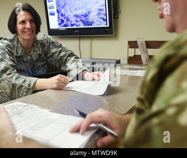 U.S. Air Force Tech. Le Sgt. Ashley Weatherly, drapeau rouge 17-1 météorologue du 1er Escadron de soutien opérationnel à Langley Air Force Base en Virginie, un partenaire de coalition, les réponses des questions sur l'ensemble de la Nellis Air Force Base, Nevada, le 23 janvier 2017. L'exercice des prévisions météorologiques de la préparation des produits qui déterminent la capacité à accomplir en toute sécurité les combats air-air des missions d'entraînement au cours de l'exercice. (U.S. Photo de l'Armée de l'air par le sergent. Natasha Stannard) Banque D'Images