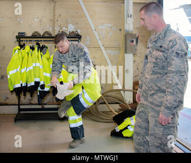 Le chef de l'US Air Force Master Sgt. Steven Nichols, 60e Escadre de la mobilité aérienne, chef du commandement sur place comme l'équipement de protection d'un membre de la 1re classe Cody George, 60e Escadron de Port de l'antenne, l'air lors d'un travaille avec des aviateurs à l'événement programme Travis Air Force Base en Californie, 27 janvier 2017. Le programme comprend l'escadre en interaction avec d'aviateurs canadiens à obtenir une vue détaillée de chaque mission effectuée à Travis. (U.S. Air Force photo/Louis Briscese) Banque D'Images