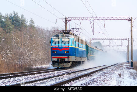 Train de voyageurs rapidement le long du couloir de neige Banque D'Images