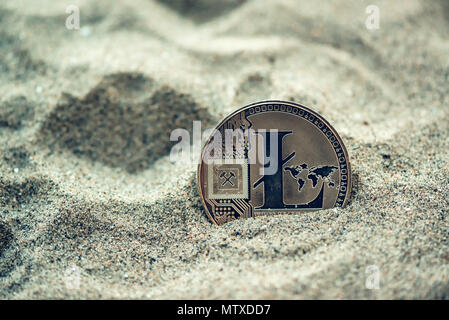 Seule Pièce litecoin cryptocurrency enterré dans le sable, conceptual image de crypto mining et trésors nouvellement trouvé la métaphore, selective focus Banque D'Images