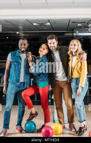 Jeunes amis multiethnique posing at bowling club Banque D'Images