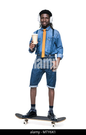 Happy african american man listening music et holding coffee pour aller isolated on white Banque D'Images