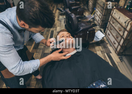 Les clients masculins coiffure peigne à barbe barbier Banque D'Images