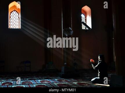 Un garçon du Cachemire à l'intérieur de l'historique Grand prie ou Mosquée Jamia Masjid durant le mois saint du Ramadan à Srinagar, Cachemire sous administration indienne. Les musulmans du monde entier célèbrent le mois de Ramadan, le mois le plus saint dans le calendrier islamique durant laquelle les dévots vite de l'aube au crépuscule. Banque D'Images