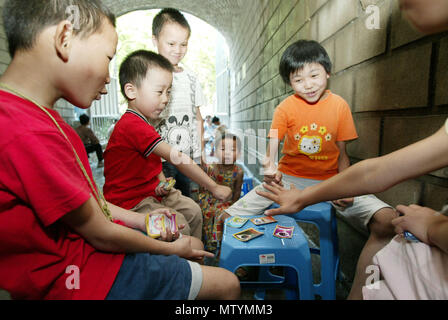 (180531) -- BEIJING, 31 mai 2018 (Xinhua) -- dans le fichier photo prise le 4 juillet 2004, les enfants qui cherchent un abri contre la chaleur de l'été jouer un jeu de carte à Hangzhou, Zhejiang Province de Chine orientale. Que la Chine célèbre la Journée internationale des enfants, il se pose l'occasion pour les adultes de penser en arrière sur les joies de l'enfance. Avec l'évolution de la technologie et le mode de vie, les enfants sont exposés à un plus large éventail de divertissements. Néanmoins, la joie reste un motif de la petite enfance n'importe comment ses formes changent avec le temps. (Xinhua/Liang Zhen) (LMM) Banque D'Images