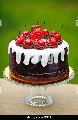 Gâteau d'anniversaire au chocolat décoré de cerises et le nombre 5 Banque D'Images