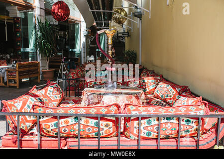 Vide café turc dans le style traditionnel - textiles lumineux et des oreillers avec narguilé debout sur la table Banque D'Images