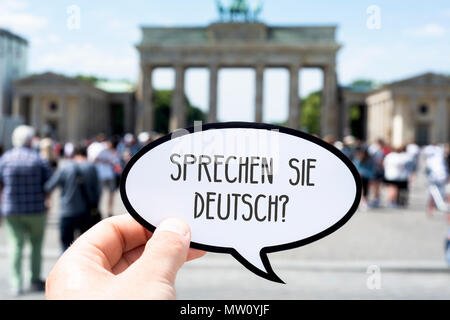 Libre de la main d'un jeune homme de race blanche montrant une bulle avec la question Sprechen Sie Deutsch, parlez-vous allemand écrit en allemand, en Banque D'Images