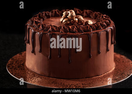 Gâteau au chocolat avec des noix sur fond noir Banque D'Images