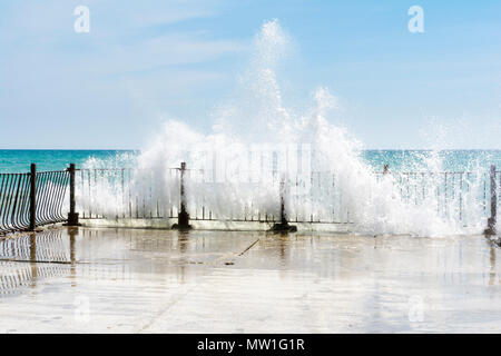 De grosses vagues sur la jetée de concassage de pierres incurvées, sur sunnny, météo big tide. Banque D'Images