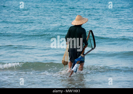Pêcheur portant un chapeau de paille, la plage Cua Dai à Hoi An, Vietnam Banque D'Images
