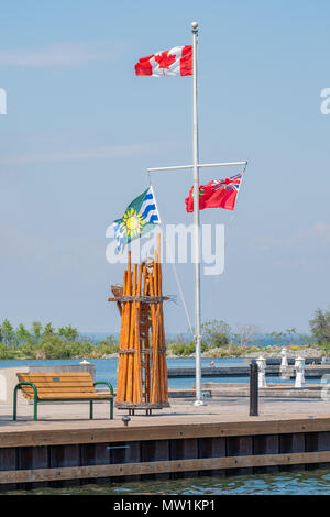 Je vois des drapeaux sur l'Orillia, Ontario Canada waterfront sur une chaude journée ensoleillée. La sculpture "Le Weirâ » est inclus dans la scène. Banque D'Images