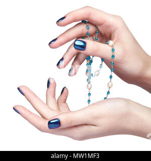 Femme avec perles Bijoux de costume. Les doigts avec un bleu brillant ongles manucure. Girl's hands avec bijouterie isolé sur fond blanc Banque D'Images