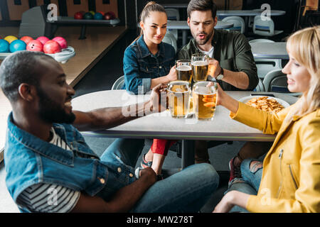 Groupe d'amis de trinquer à la bière de tasses bowling club Banque D'Images