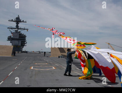 NORFOLK, Virginie (27 avril 2017) -- 1ère classe Quartier-maître José Triana, affecté à l'unité Pre-Commissioning Gerald R. Ford (CVN 78), s'attache à une ligne de drapeaux du signal. Ford's 'top' sur les lignes sont testés par le poids de la navigation du navire. Banque D'Images