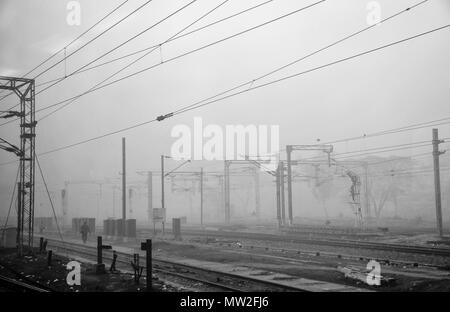 Un nœud ferroviaire près de Agra en Inde. Scène en noir et blanc, lourd matin la pollution, un étrange paysage, lignes aériennes, et les travailleurs sur les pistes Banque D'Images