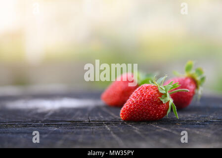 Fraises fraîches se trouve sur oak stump, vue de côté, la copie de l'espace pour le texte. Des histoires sur la vie rurale en Ukraine Banque D'Images