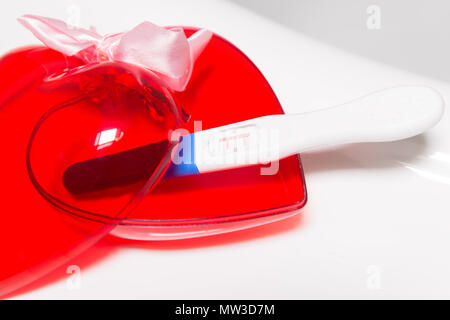 Test de grossesse positif et coeur sur baignoire Banque D'Images