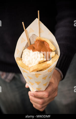 Man holding Frites avec sauce Banque D'Images