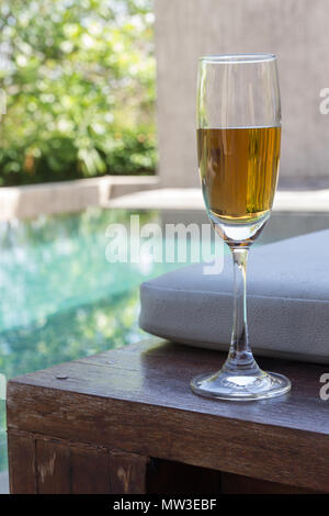 Verre de vin sur le lit à côté de la piscine Banque D'Images