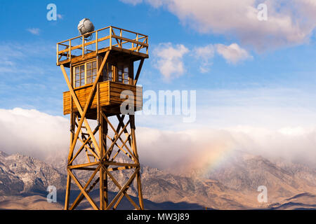 Un arc-en-ciel se forme dans les montagnes de la Sierra Nevada derrière une tour de garde à Manzanar Banque D'Images