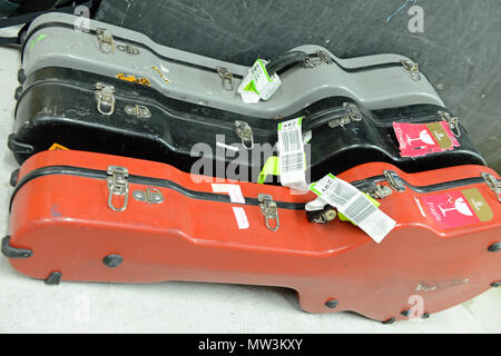 Sélection de différentes couleurs de guitare flight cases situées en coulisses lors d'un concert avec les étiquettes sur l'embarquement Banque D'Images