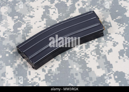 Fusil M16 magazine avec des cartouches sur fond uniforme de camouflage Banque D'Images