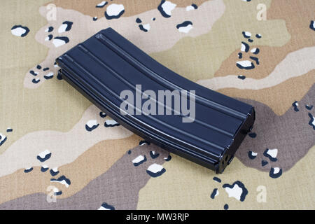 Fusil M16 magazine avec des cartouches sur fond uniforme de camouflage Banque D'Images