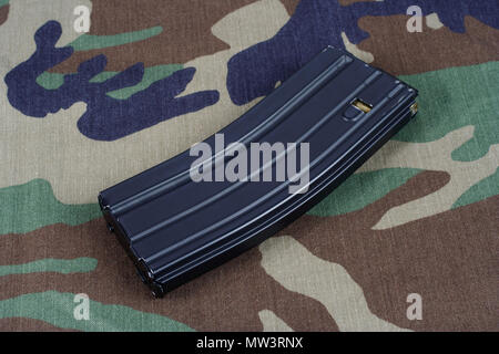 Fusil M16 magazine avec des cartouches sur fond uniforme de camouflage Banque D'Images