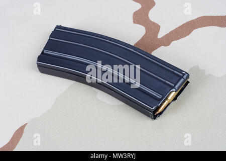 Fusil M16 magazine avec des cartouches sur fond uniforme de camouflage Banque D'Images