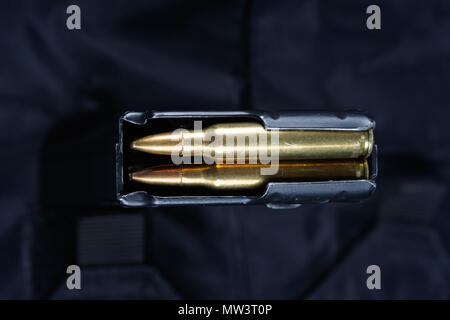 Fusil M16 magazine avec cartouches sur uniforme noir Banque D'Images