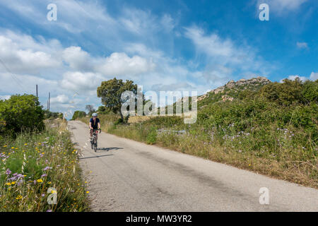 Cycliste féminine rouler à vélo à travers la belle campagne de la Sardaigne. Banque D'Images