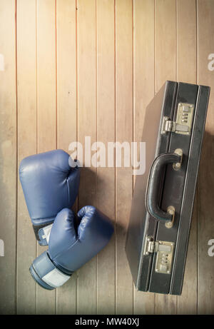 Des gants de boxe et d'affaires valise sur fond de bois. Vue d'en haut. Mise à plat. Banque D'Images