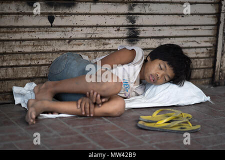 Un enfant de la rue sur le trottoir au centre-ville de Cebu City, Philippines Banque D'Images