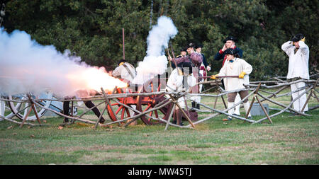 Tirant du canon à la fin de la journée dans la ville historique de Colonial Williamsburg. Capturé en action, les oreilles sont couvertes d'eau et de la fumée au bout de la flèche. Banque D'Images