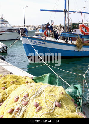 Bateau de pêche bleu et blanc à Astrakeri Harbour, Corfou, Grèce avec des filets de pêche en premier plan Banque D'Images