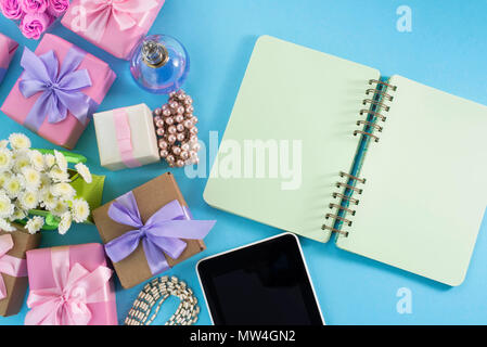 Arrière-plan de fête cadeau poster satin bouquet de fleurs perle bijoux smartphone tablette portable fond bleu. Vue d'en haut copie espace f Banque D'Images