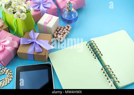 Arrière-plan de fête cadeau poster satin bouquet de fleurs perle bijoux smartphone tablette portable fond bleu. Vue d'en haut copie espace f Banque D'Images