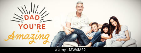 Image composite de family sitting on sofa smiling at camera Banque D'Images