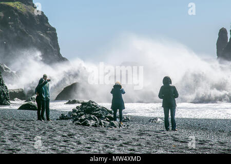 Vík í Mýrdal plage ; plage Reynisfjara qui jouit a cailloux noirs, célèbre de sable noir, colonnes de basalte et les formations rocheuses au large de Reynisdrangar. Un village de bord de mer à distance où la plage est également bien connu pour les grandes vagues de l'espadrille dangereusement. La plage de Reynisfjara qui jouit cependant, peut être un endroit dangereux par mauvais temps, et des touristes qui s'aventurent trop près de l'eau peut être balayé d'un coup de leurs pieds par une puissante vague. Banque D'Images