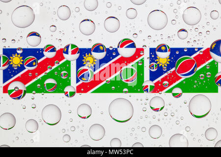 Drapeaux de la Namibie derrière un verre recouvert de gouttes de pluie. Banque D'Images