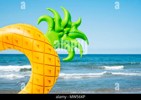 Libre de nager dans la forme d'un ananas sur la plage, avec l'océan et le ciel bleu en arrière-plan Banque D'Images