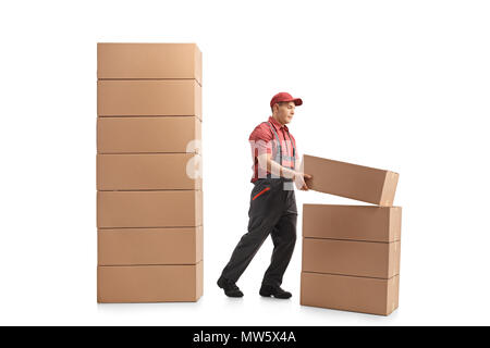 Profil complet tiré d'un auteur de placer un paquet en haut d'une pile de colis isolé sur fond blanc Banque D'Images