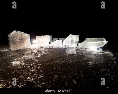 Couper la glace. Cubes écrasés éclairée avec rétroéclairage puissant. Silent Bay avec télévision niveau congelé. Le spectre de la lumière dans la glace. Banque D'Images