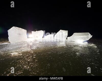 Pièces de fonte de blocs de glace. Rétroéclairage de couleur forte brillance des fissures profondes, low angle view. Loin de l'horizon. Banque D'Images