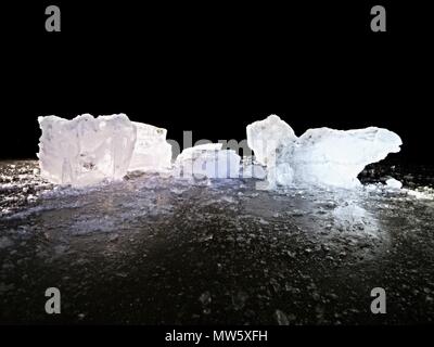 Pièces de fonte de blocs de glace. Rétroéclairage de couleur forte brillance des fissures profondes, low angle view. Loin de l'horizon. Banque D'Images