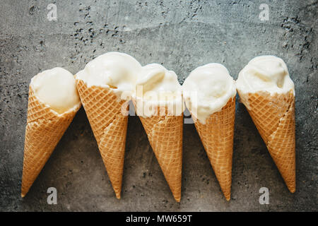Cinq délicieux de fusion des glaces en cônes gaufre gris foncé sur fond de texture Banque D'Images