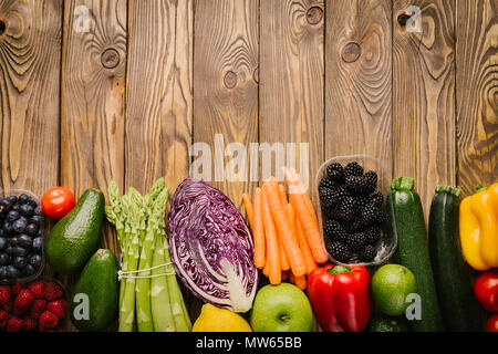 Arrangement de différents légumes et petits fruits savoureux colorés sur fond de bois. Vue de dessus avec l'exemplaire de l'espace. Concept d'aliments sains. Studio Shot Banque D'Images